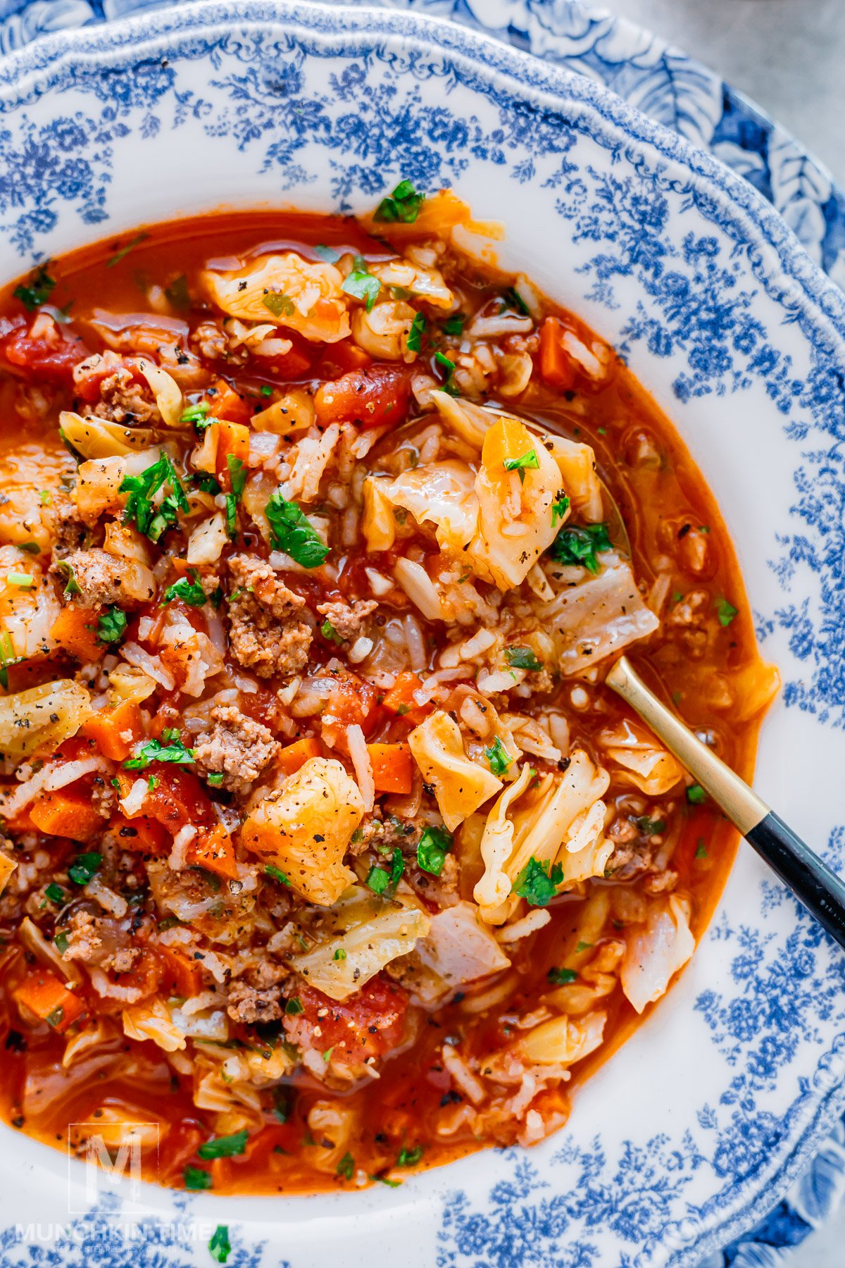cabbage roll soup in a blue bowl.