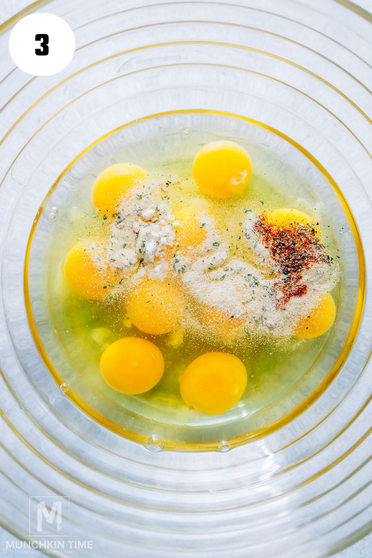 spices added to the eggs in the bowl.