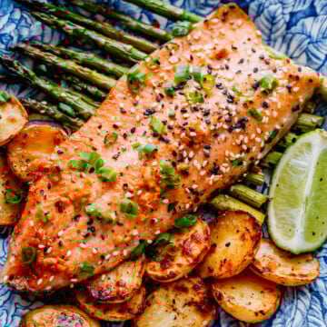 baked trout and vegetables with toasted sesame seeds and sliced green onions.