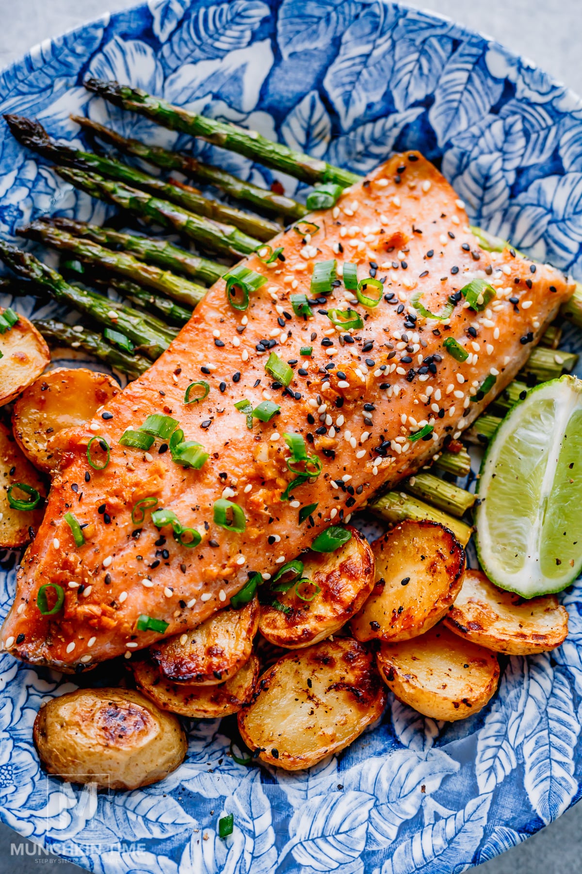 baked trout and vegetables with toasted sesame seeds and sliced green onions.