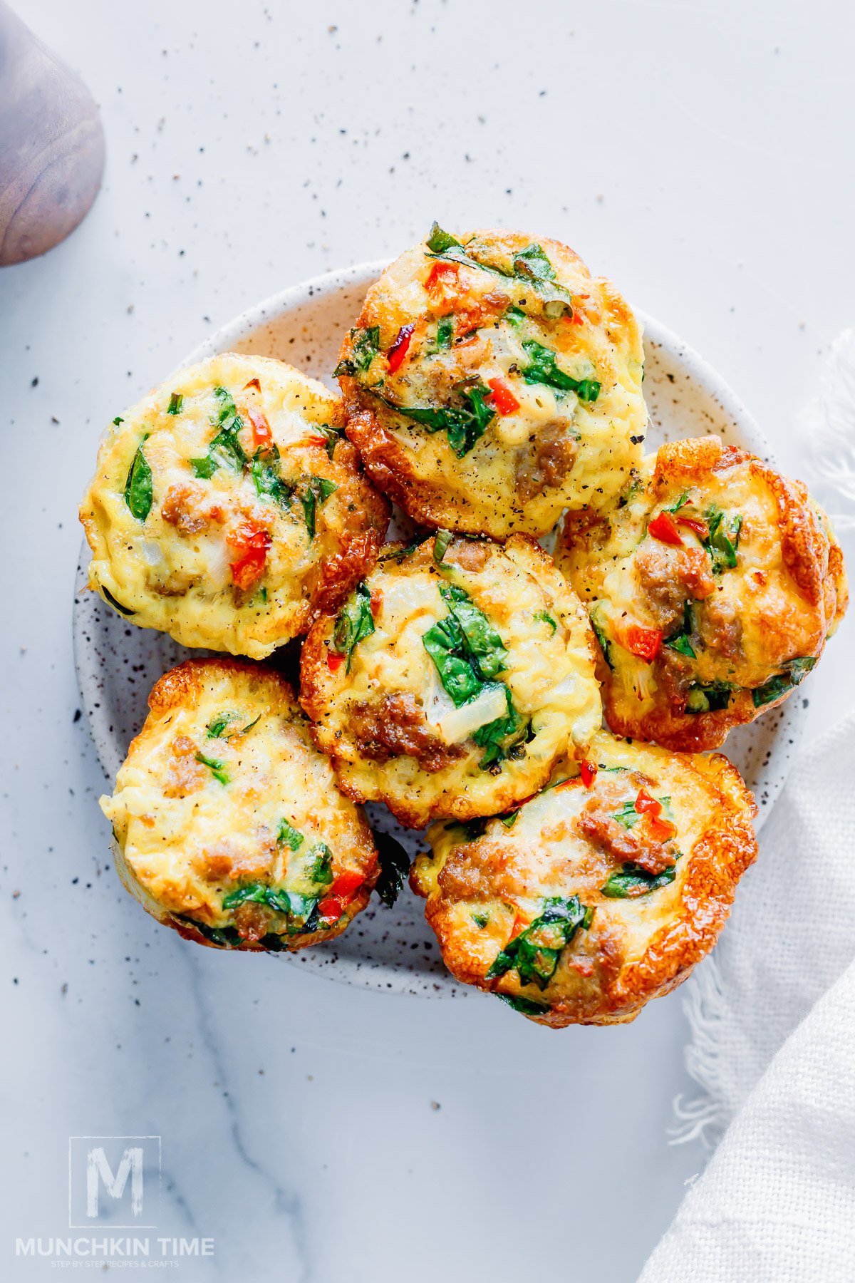 Breakfast Egg Muffins with Sausage and Spinach on a serving plate.