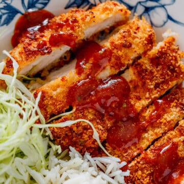 sliced air fryer chicken katsu with sauce on top.