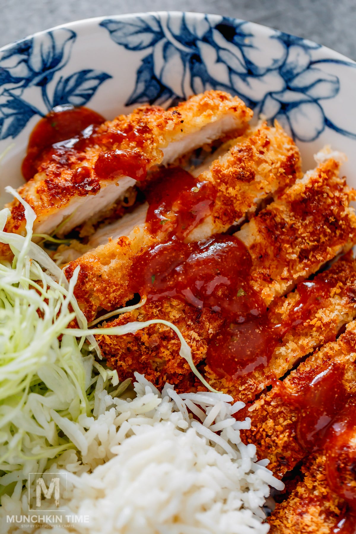 sliced crispy air fryer chicken katsu with sauce on top.