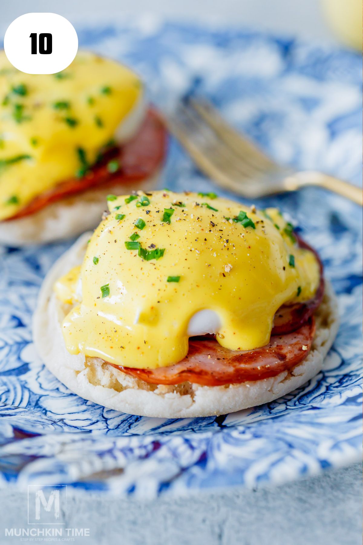 homemade eggs Benedict garnished with chives and black pepper ready for serving.
