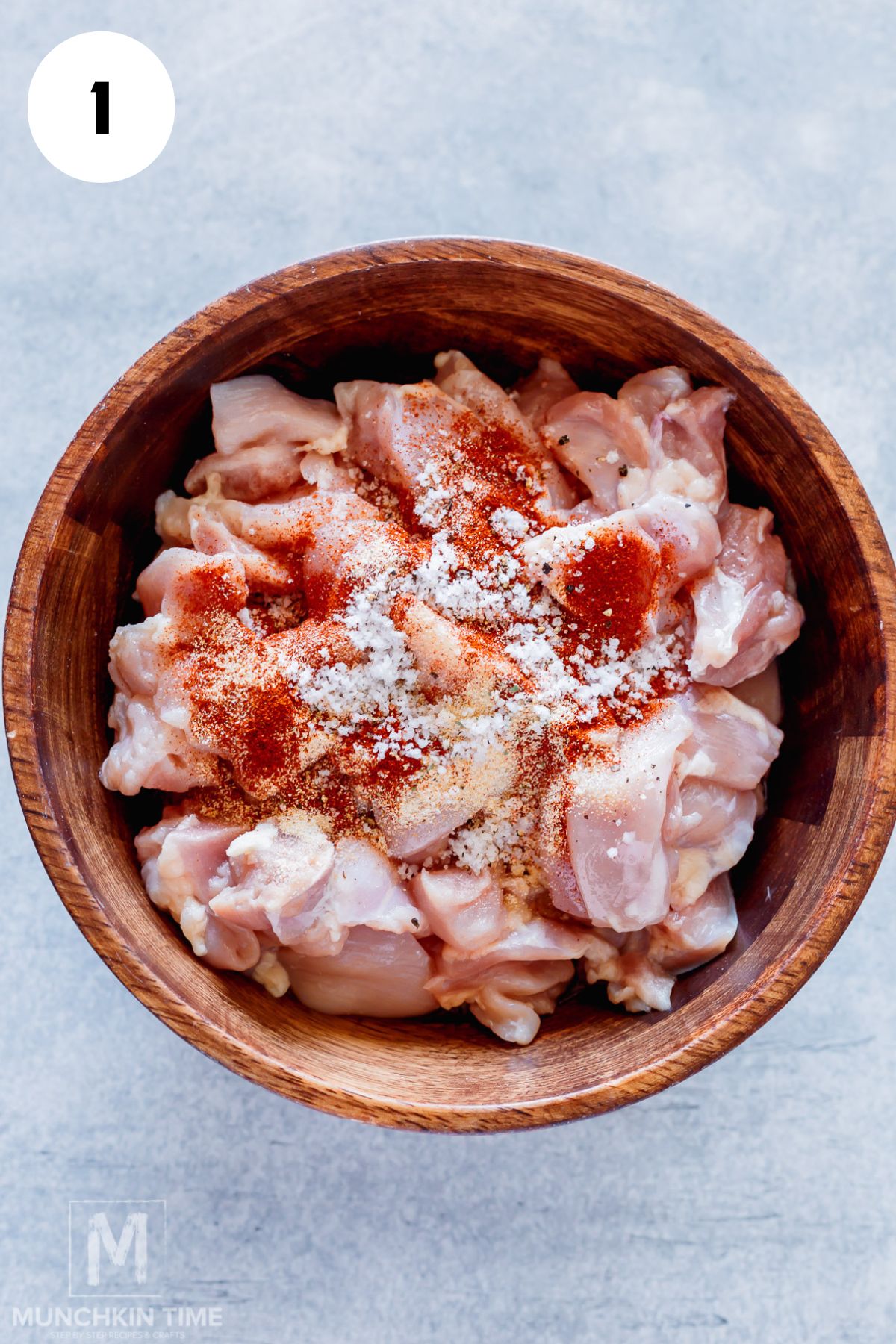 spices added to the bowl with chicken thighs.