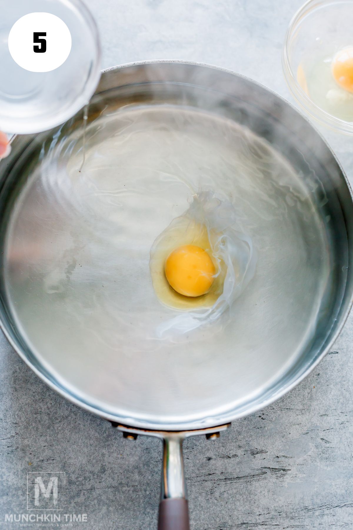 egg added to the skillet with simmering water with vinegar.