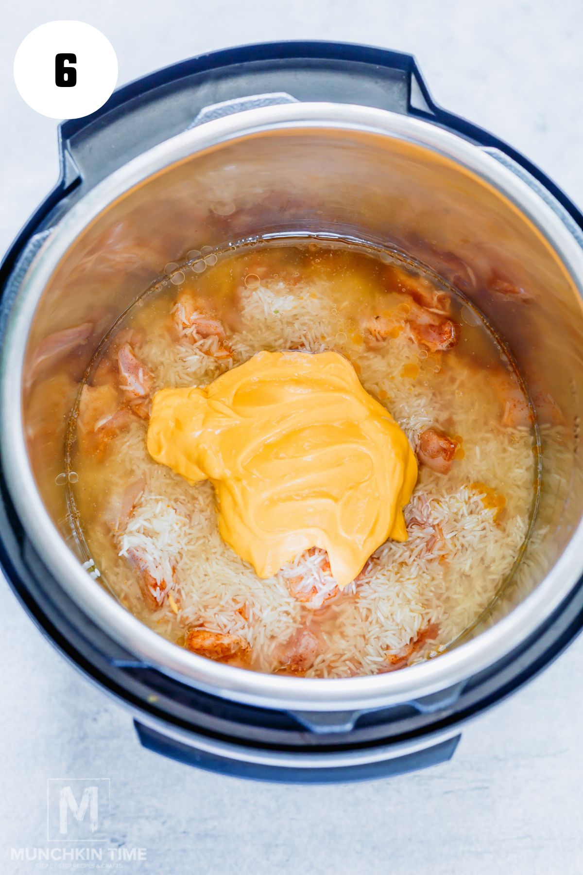 Dairy free Cheese added to the pot with seasoned chicken thighs and rice.