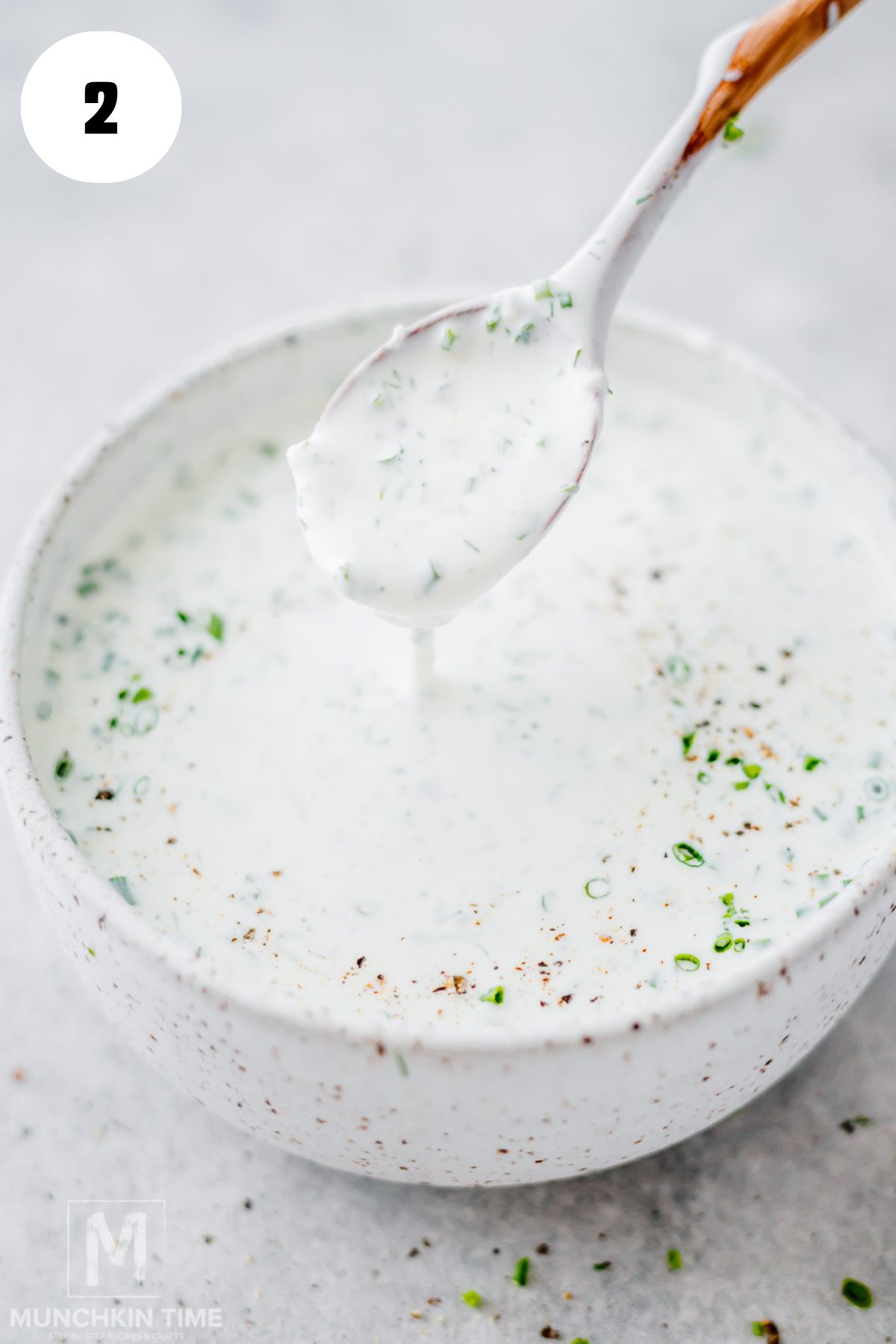 Whisking homemade ranch dressing until creamy and the fresh herbs are evenly combined.