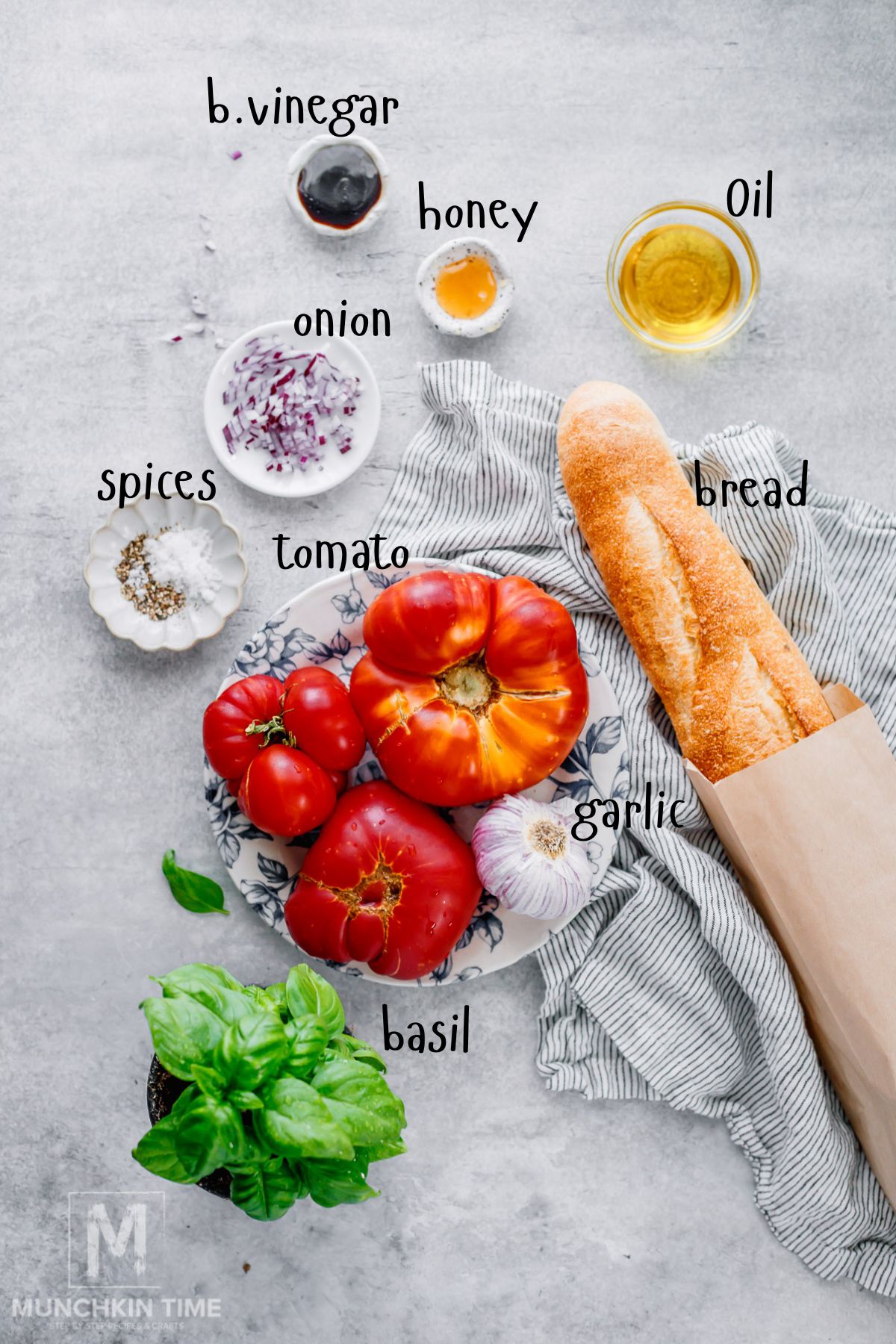 Ingredients for heirloom tomato bruschetta arranged on a kitchen counter.
