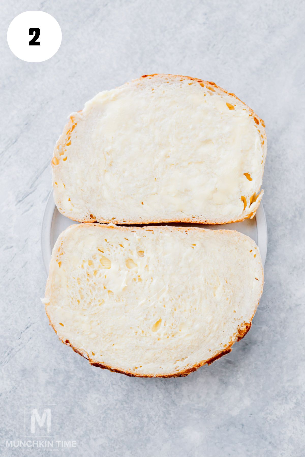 Spread softened butter evenly over one side of each sourdough slice for a golden, crispy grilled cheese crust.