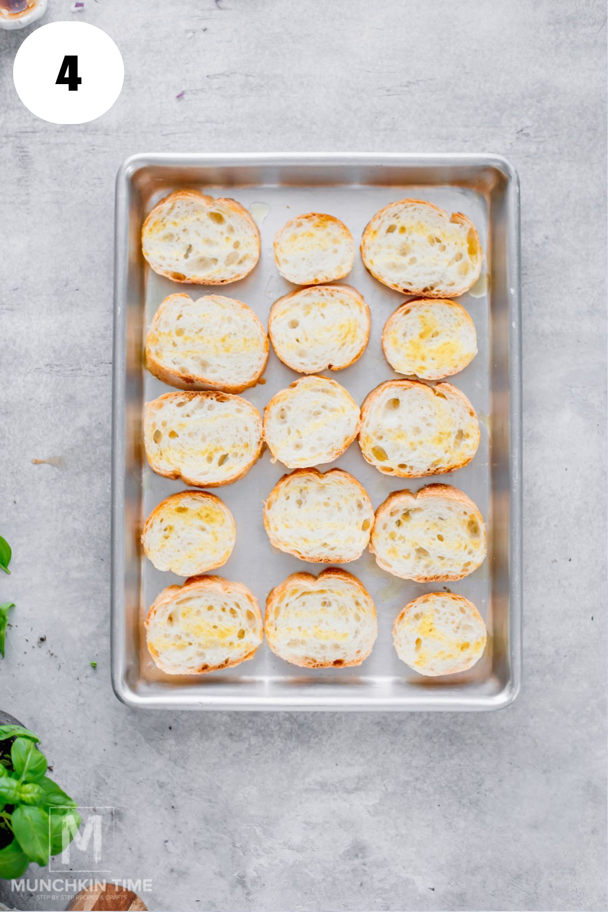 Sliced baguette arranged on a baking sheet for bruschetta.