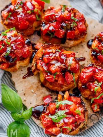 Close-up of homemade heirloom tomato bruschetta with fresh basil.