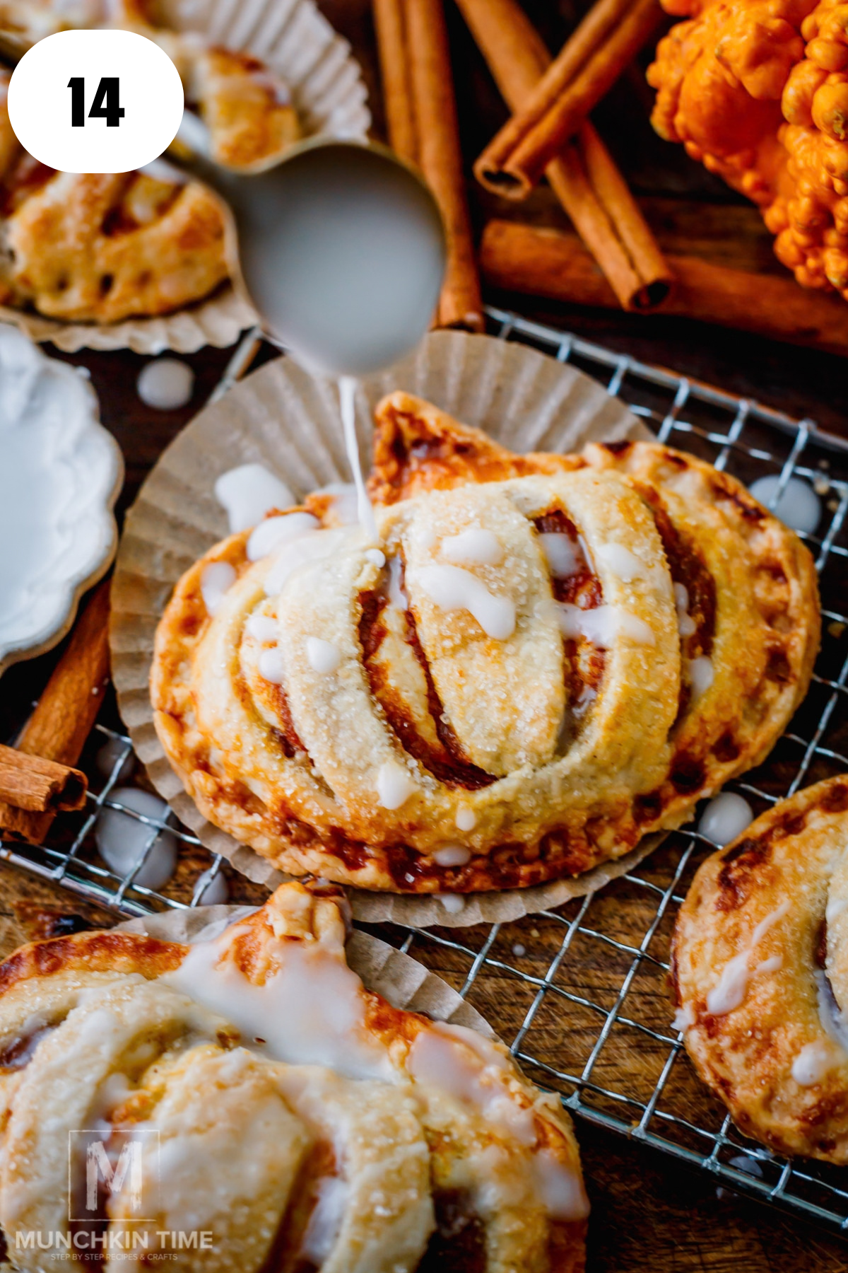 Drizzling powdered sugar glaze over cooled pumpkin cream cheese hand pies.