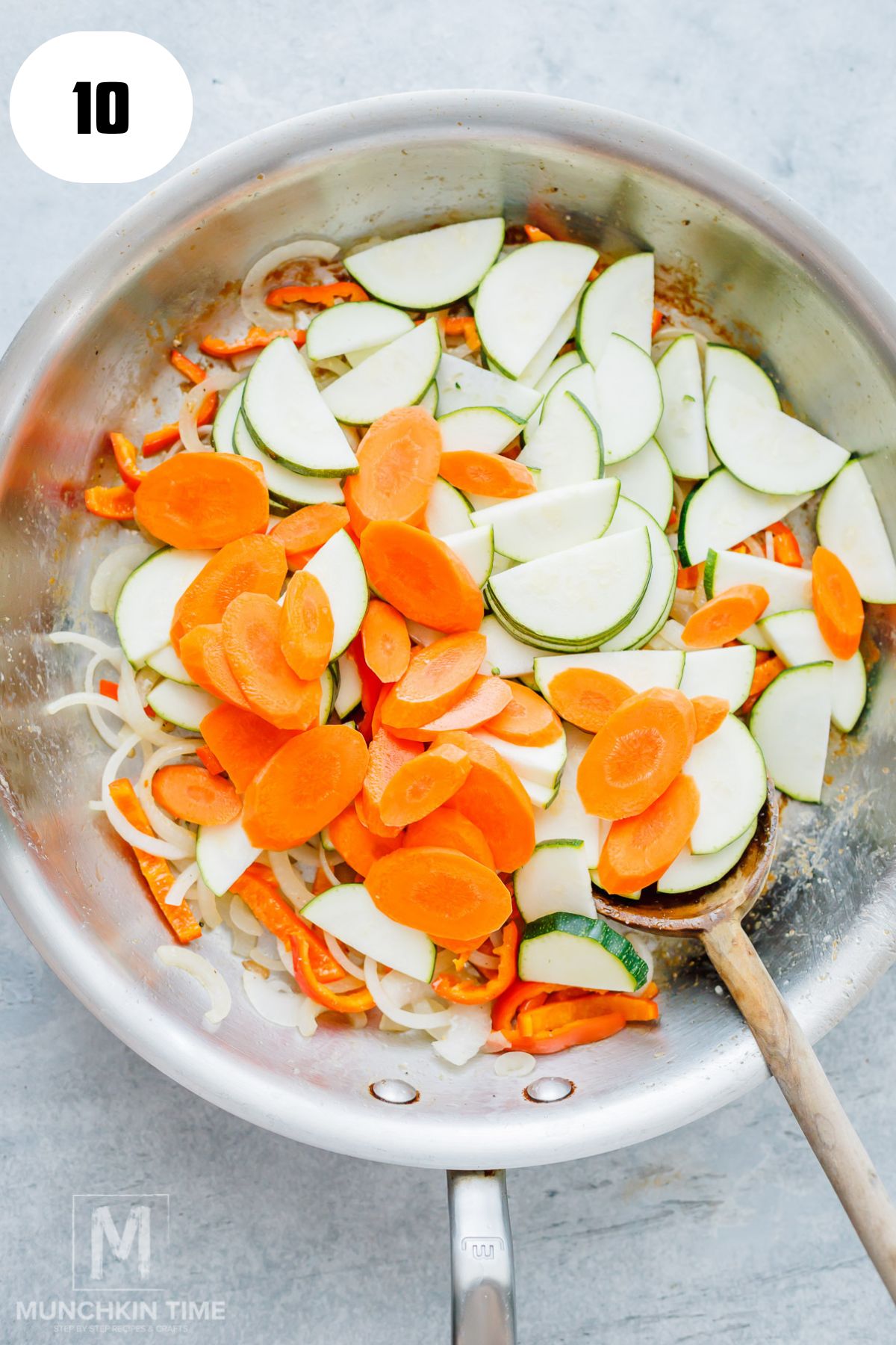 Adding zucchini and carrots to stir fried vegetables.