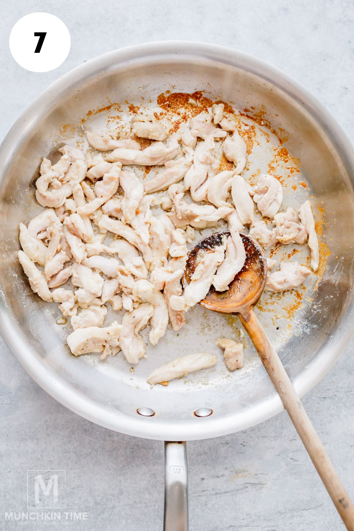 Sliced chicken cooking in a skillet.