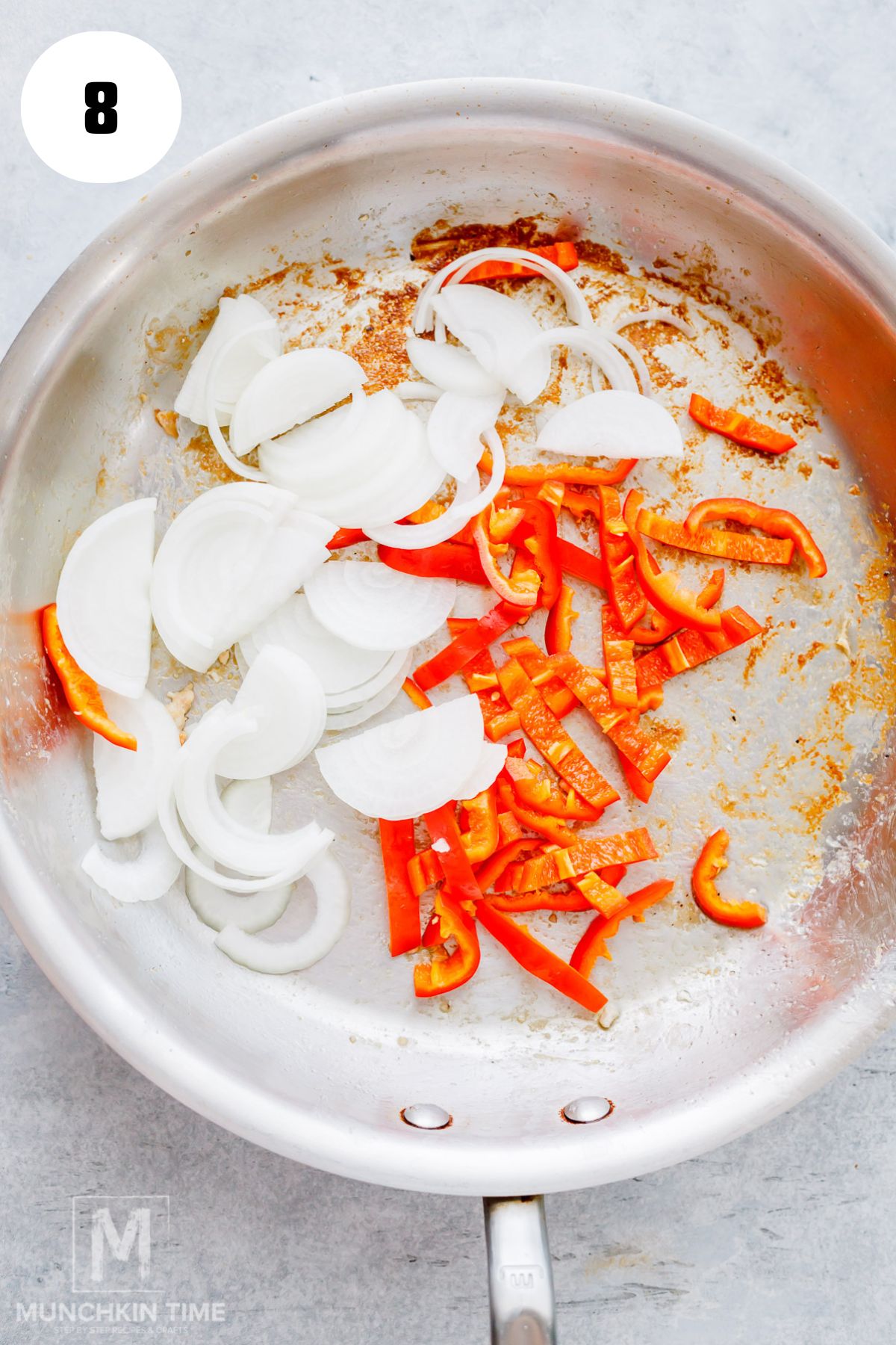 sliced onion and bell pepper added to the skillet.