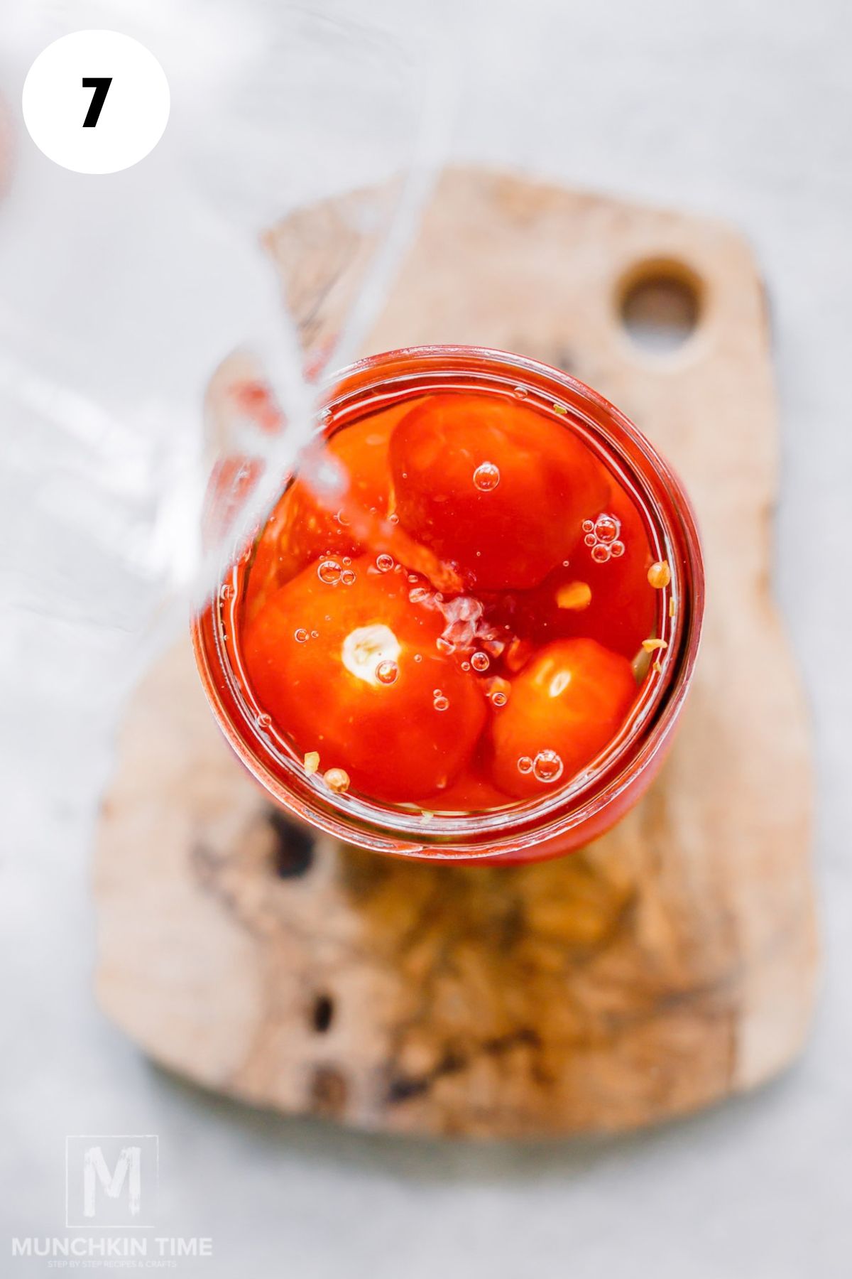 Boiling water poured over Roma tomatoes packed in glass jars