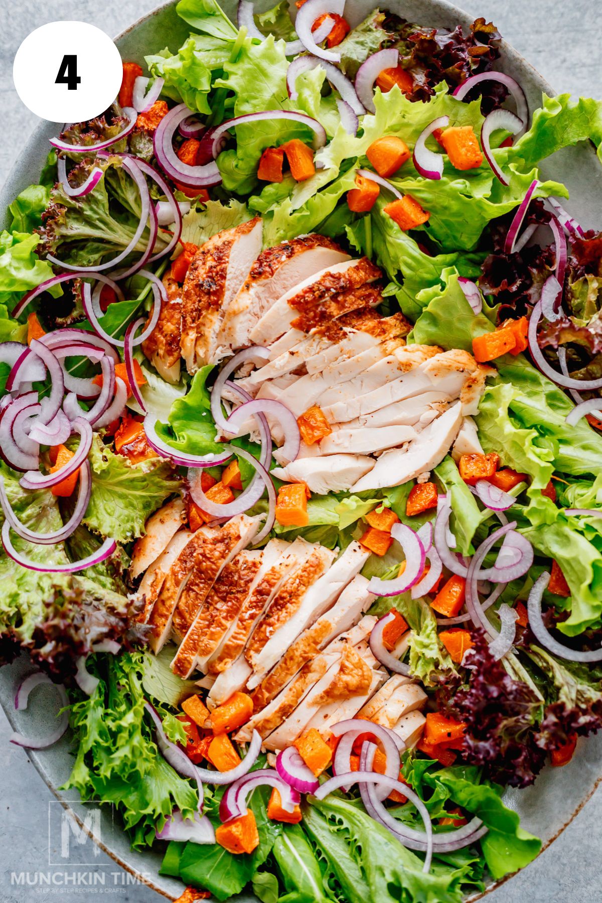 salad with chicken, roasted butternut squash and red onion over mixed greens