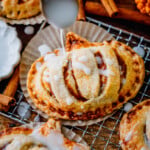 Golden pumpkin hand pies stacked and drizzled with simple glaze for a cozy fall dessert.