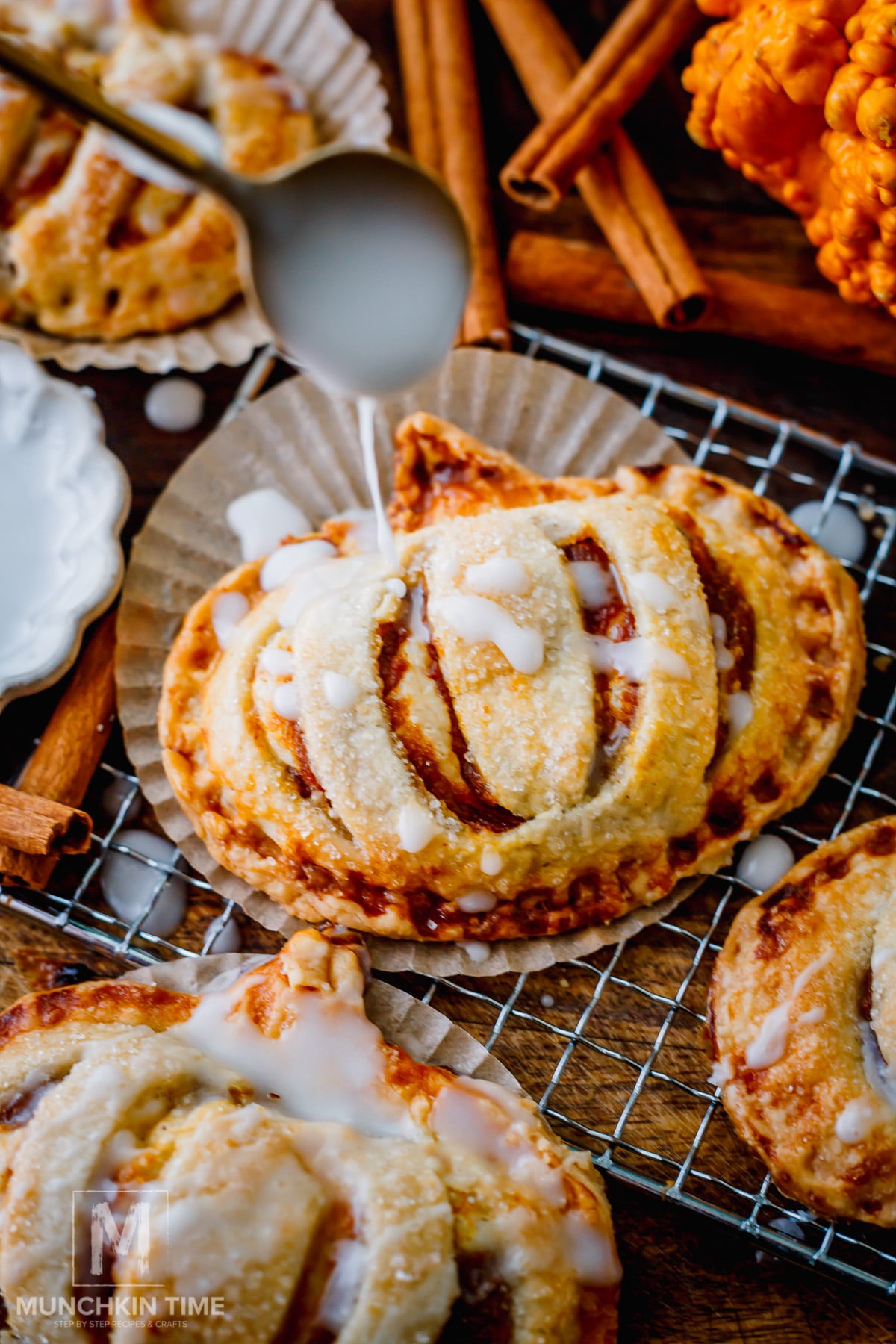 Golden pumpkin hand pies stacked and drizzled with simple glaze for a cozy fall dessert.