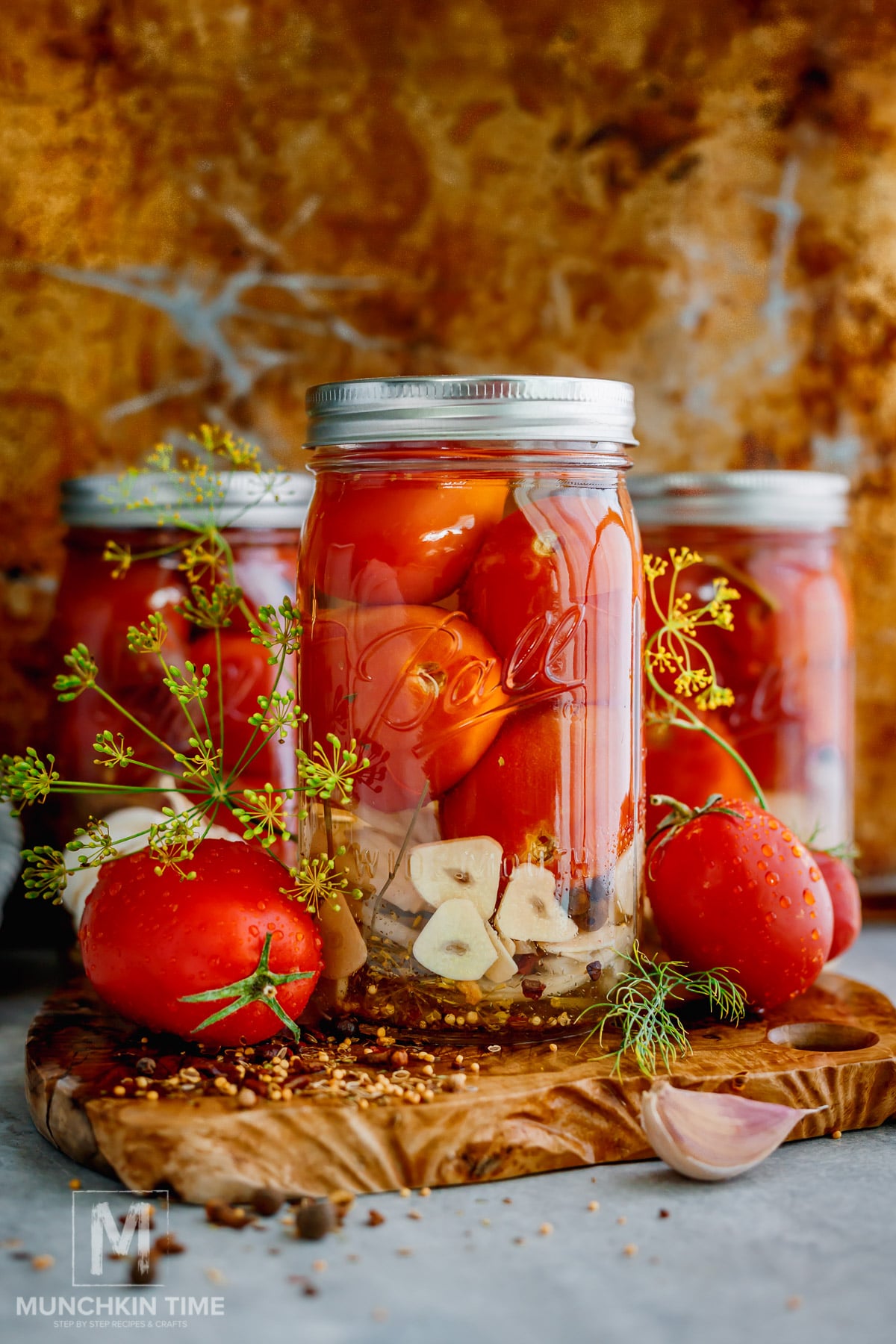 Pickled tomato jars styled with fresh Roma tomatoes dill and garlic