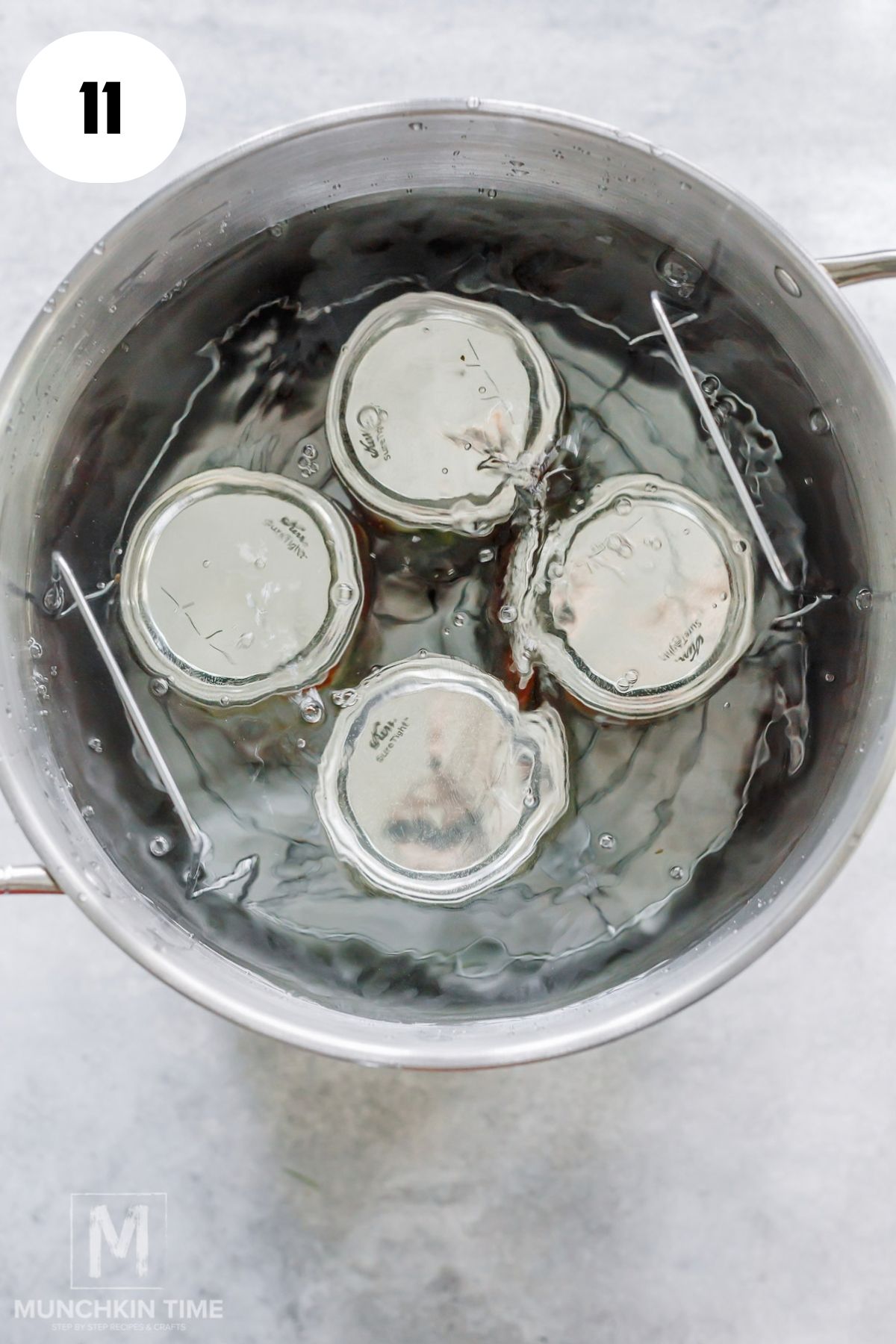 Four jars water canning in a big pot.
