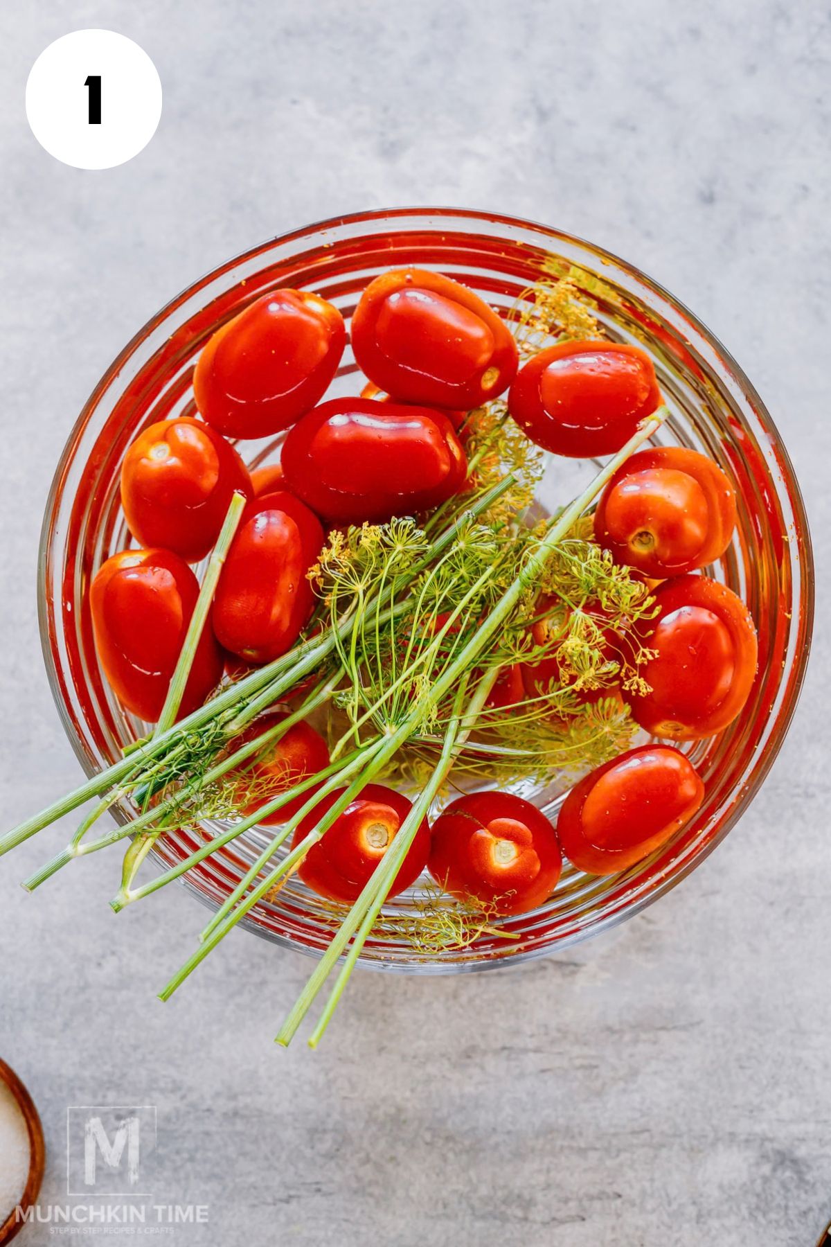 Washing fresh Roma tomatoes and pickling dill in a bowl before pickling