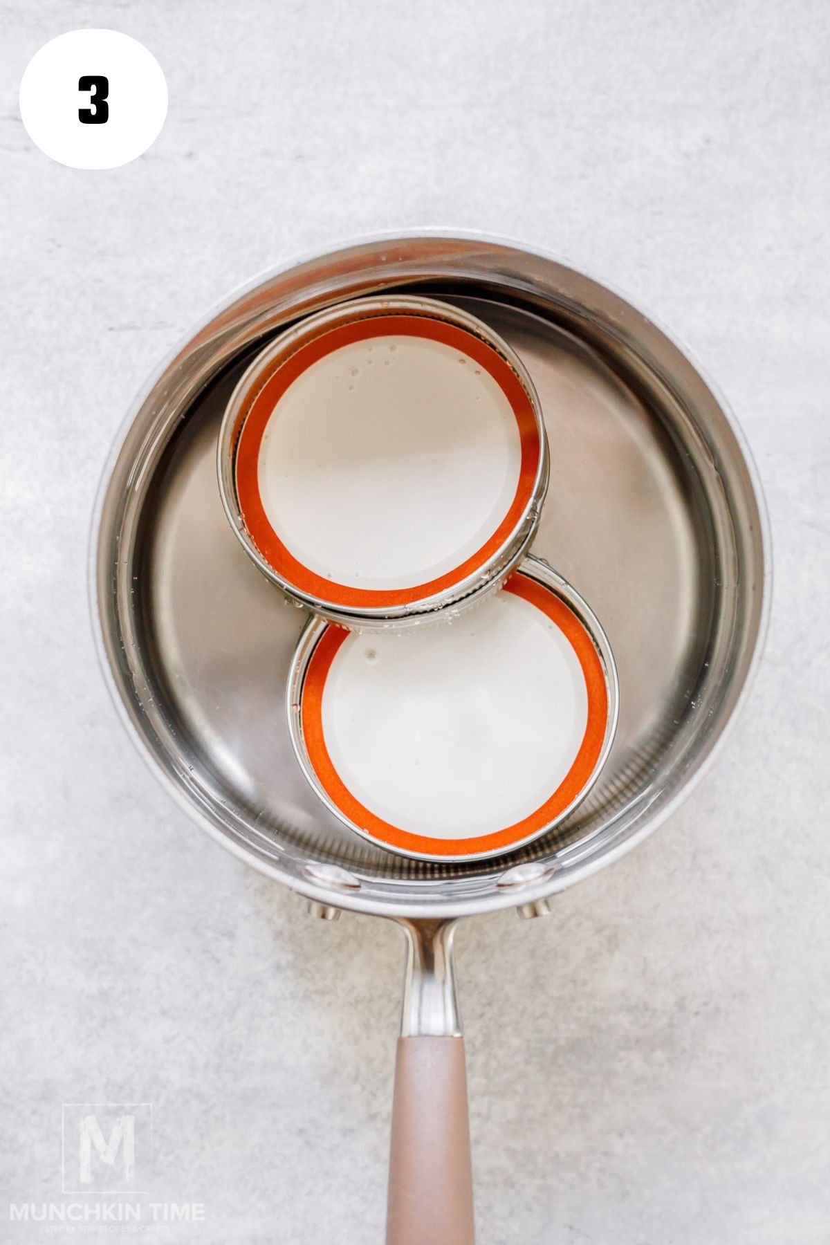Glass jar lids being prepared in hot water