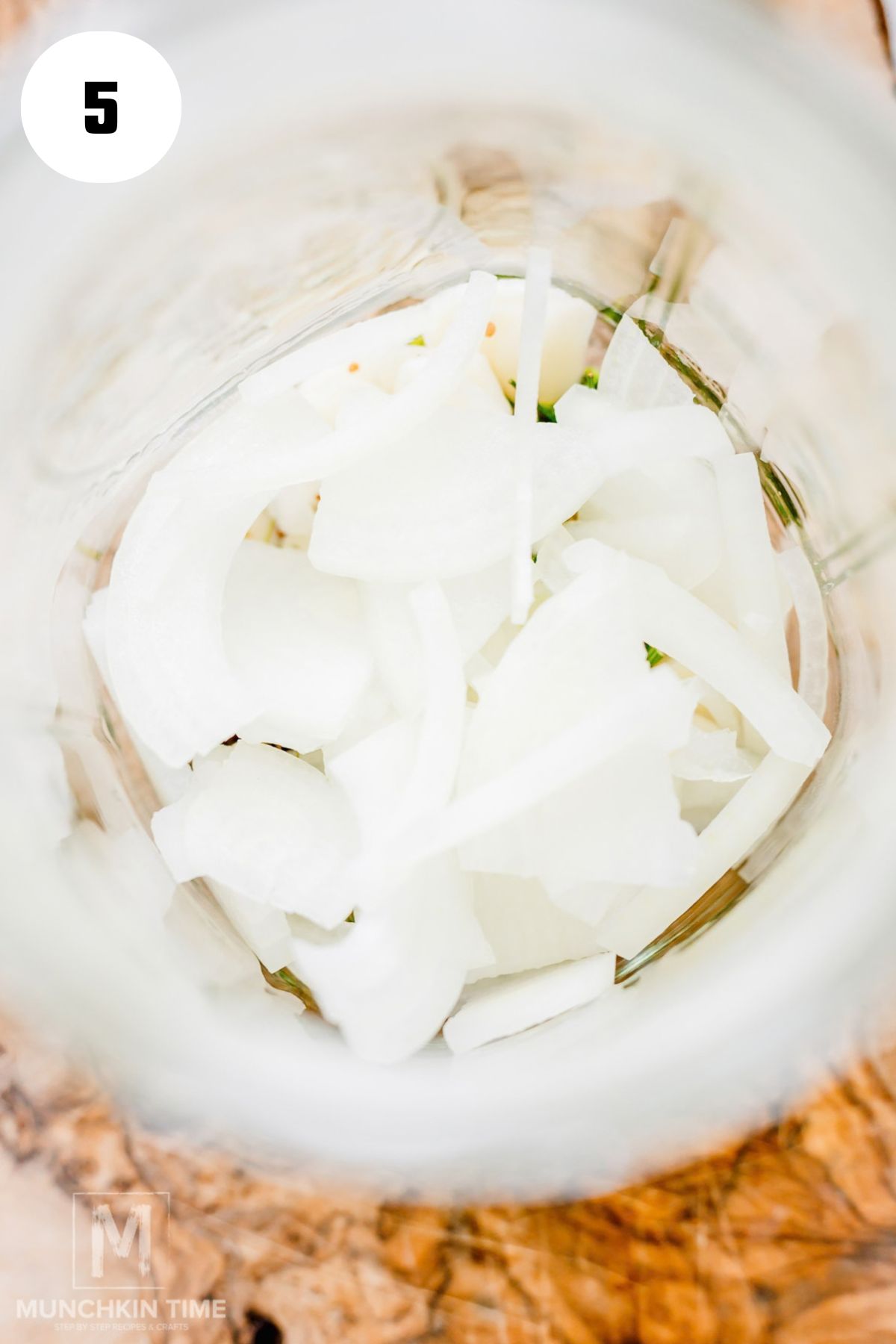 Sliced onion added to a glass jar