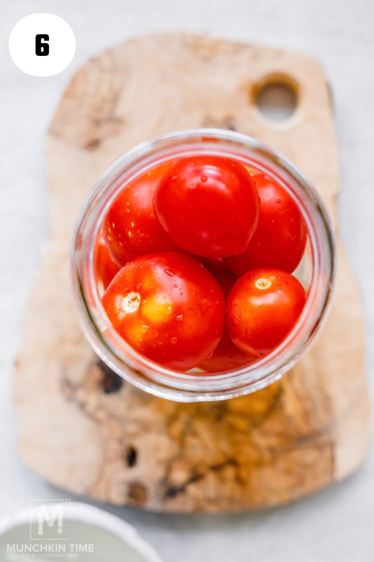 Whole Roma tomatoes packed into jars with dill garlic and onion