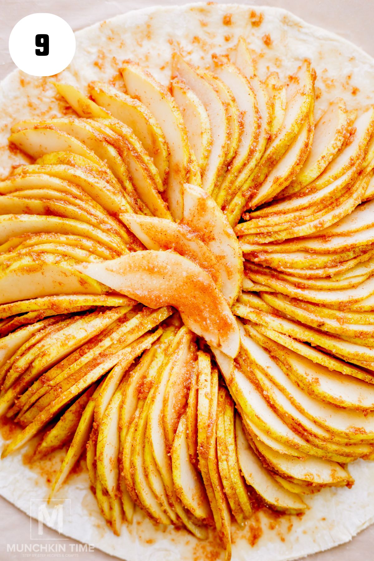 Cinnamon-coated Bartlett pear slices arranged in overlapping circles on puff pastry.