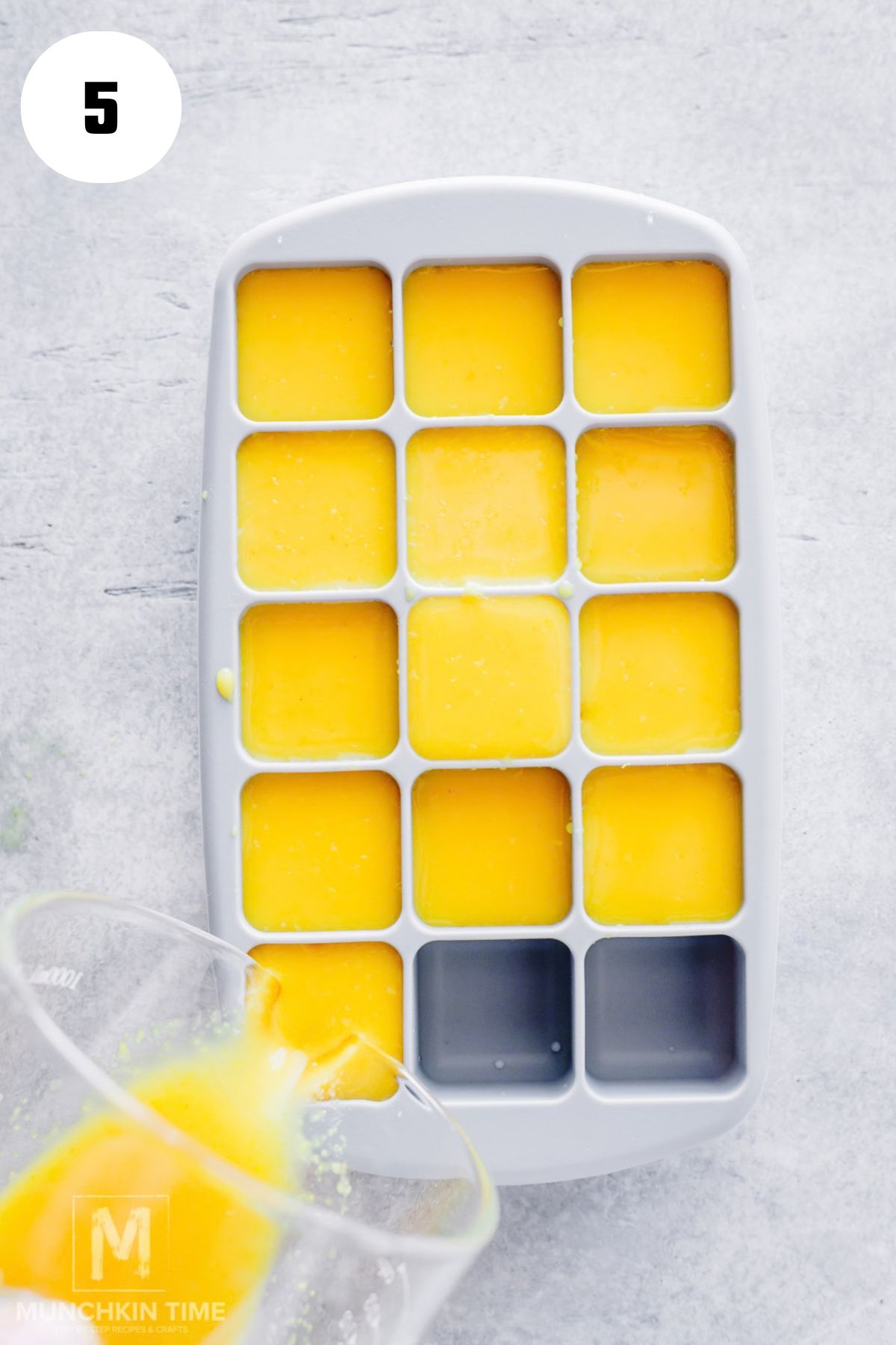 Pouring lemon ginger juice into an ice cube tray