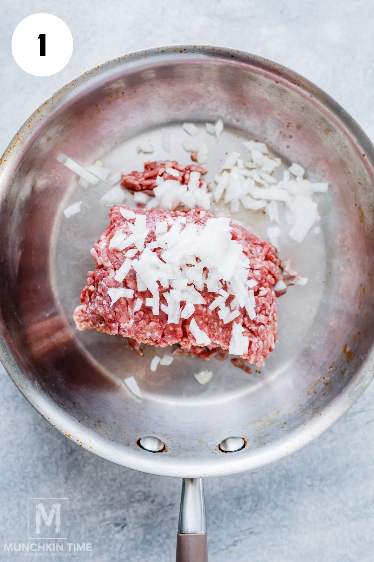 Cooking ground beef with chopped onions in a skillet for stuffed acorn squash