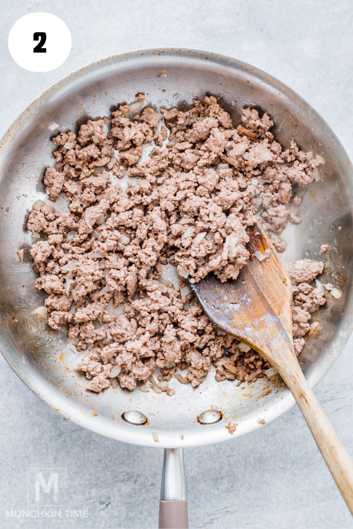 Mixing refried beans and taco seasoning into browned ground beef for acorn squash filling