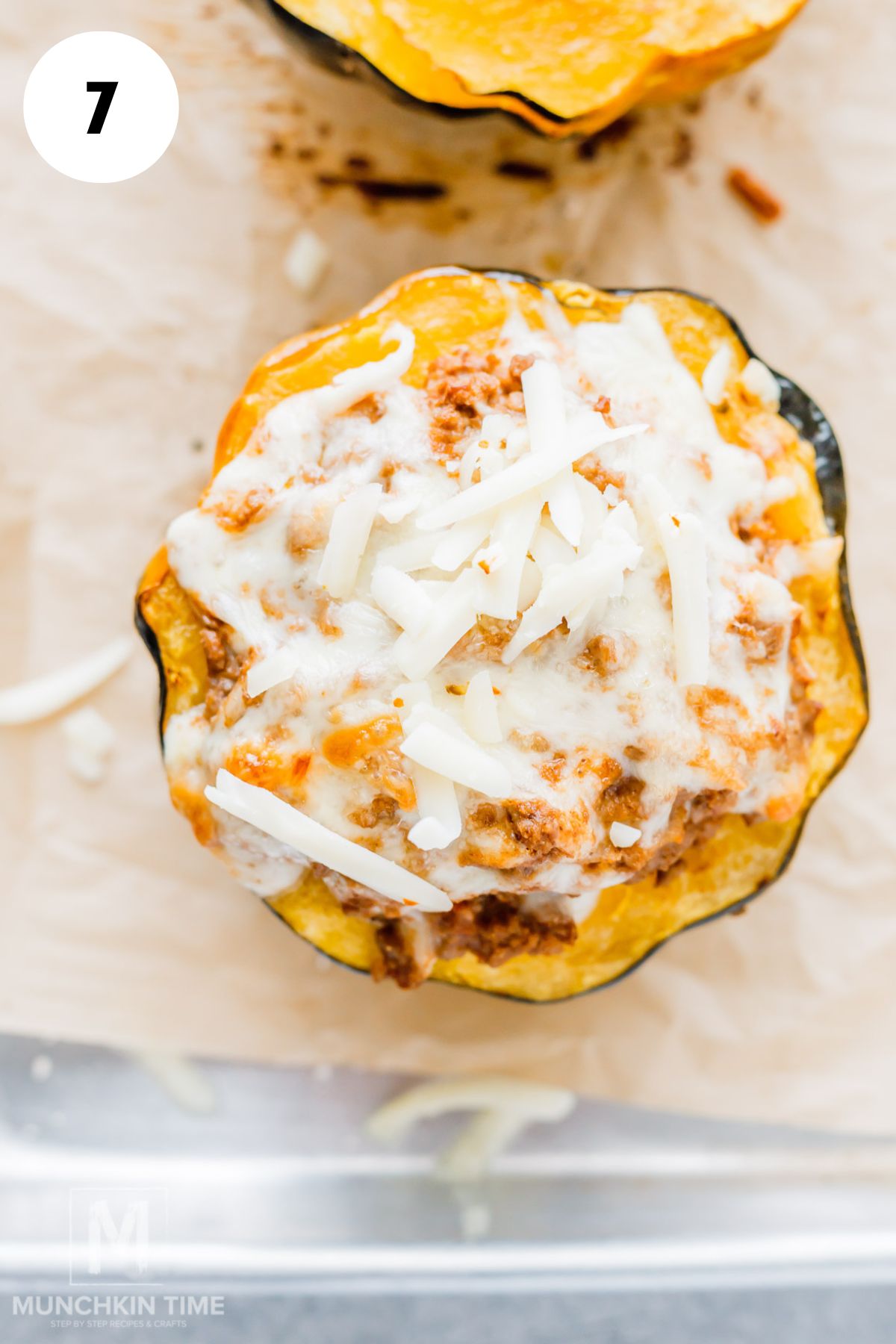 Sprinkling shredded cheddar and mozzarella over stuffed acorn squash halves