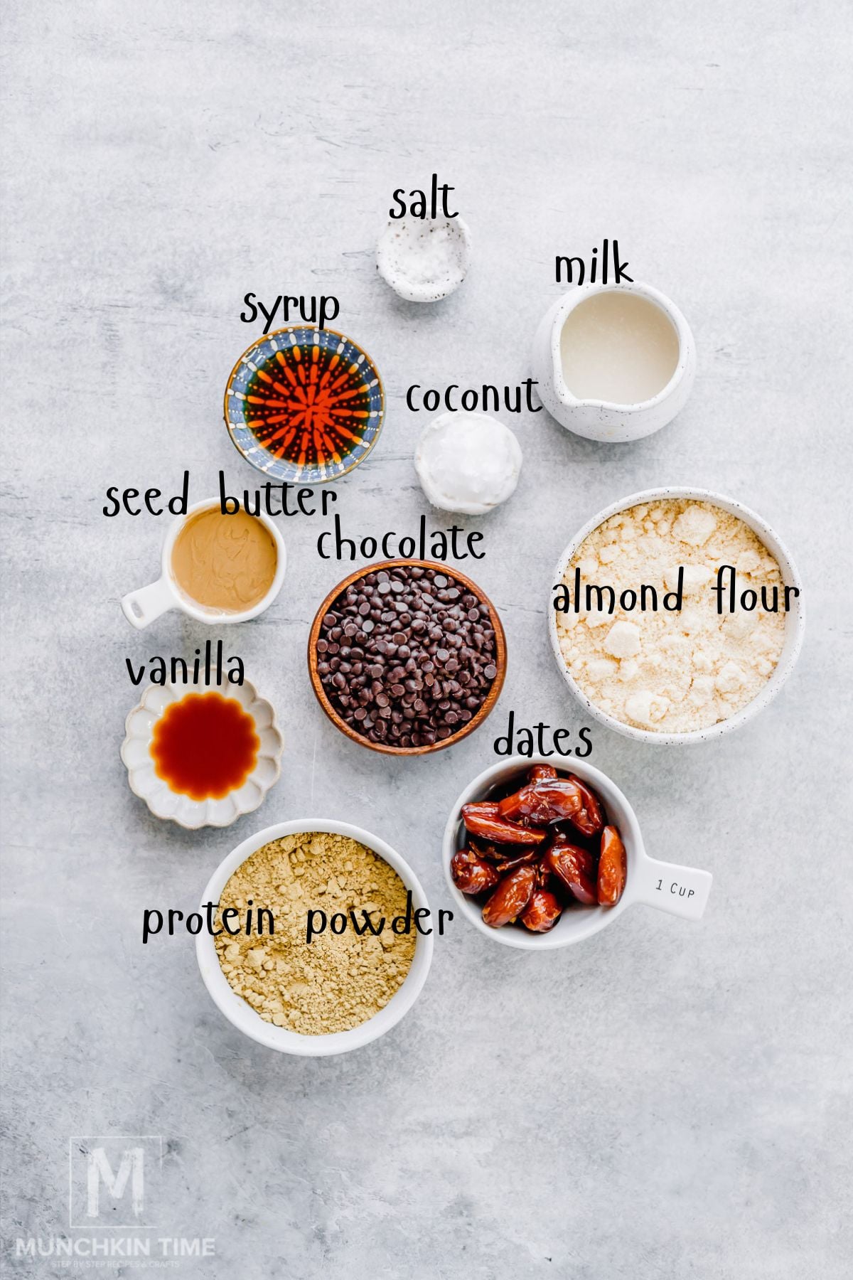 Ingredients for cookie dough protein bars including almond flour, protein powder, Medjool dates, nut butter, and dark chocolate chips