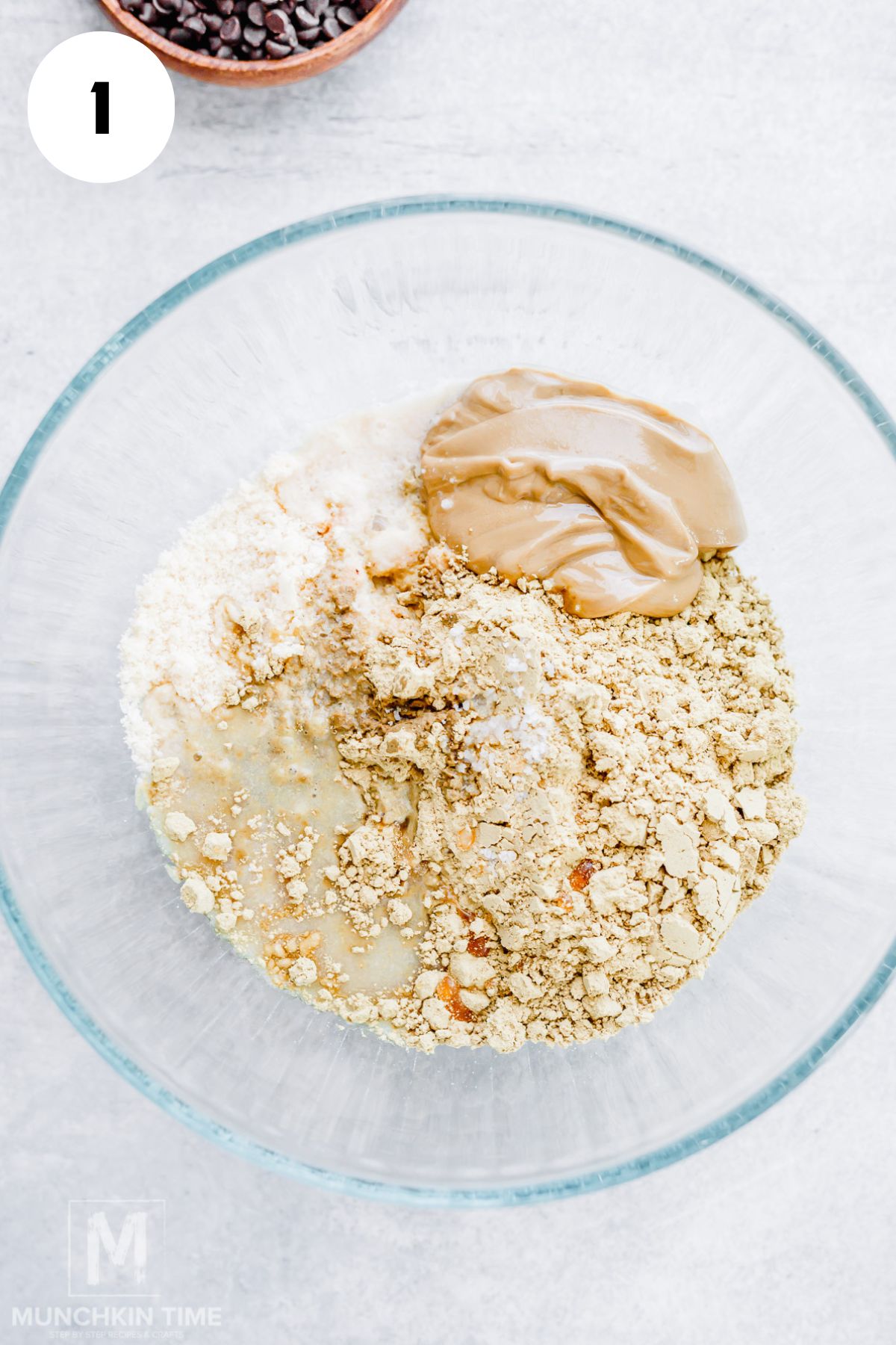Mixing almond flour, protein powder, nut butter, and maple syrup in a bowl