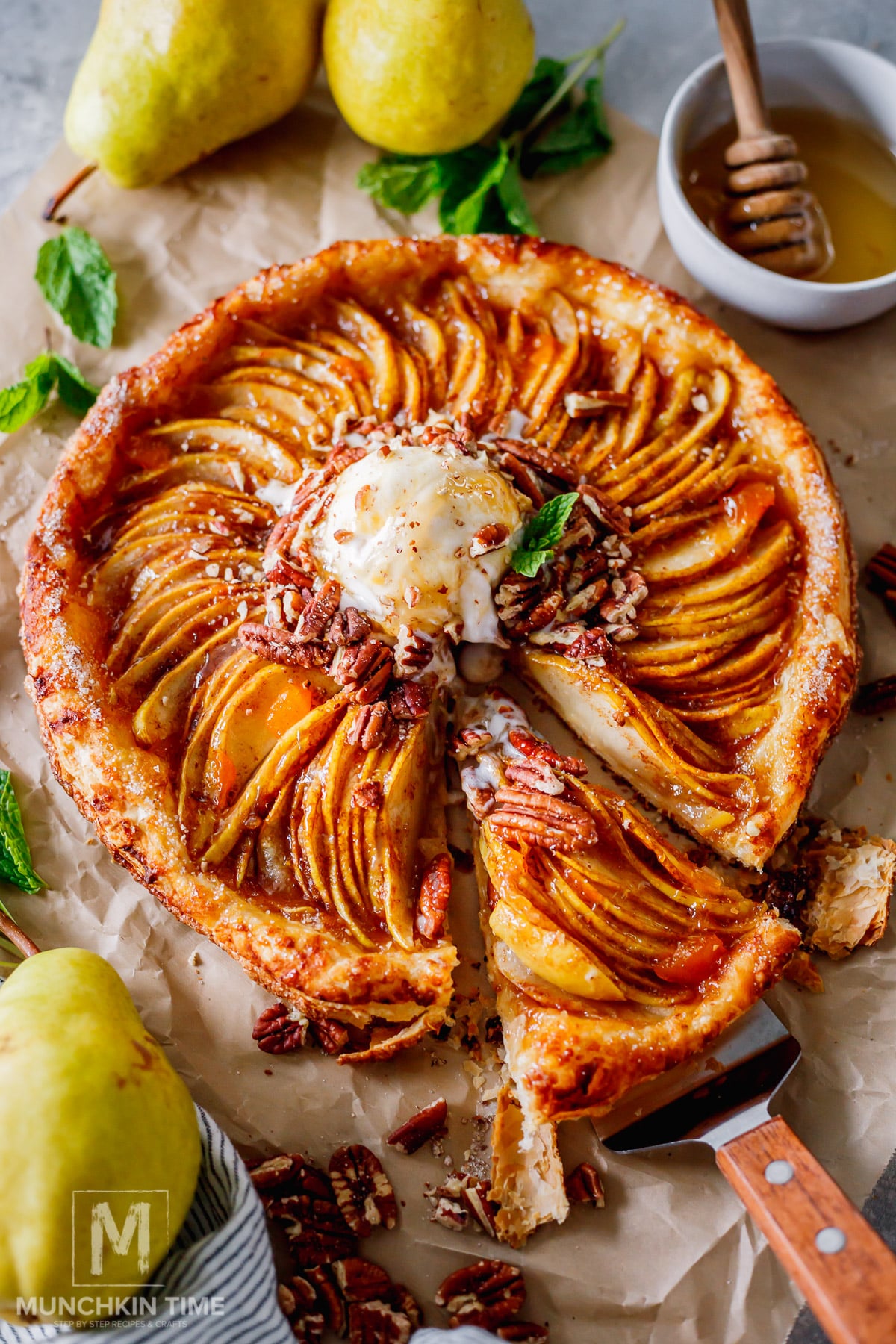 Slice of warm pear galette topped with melting vanilla ice cream.