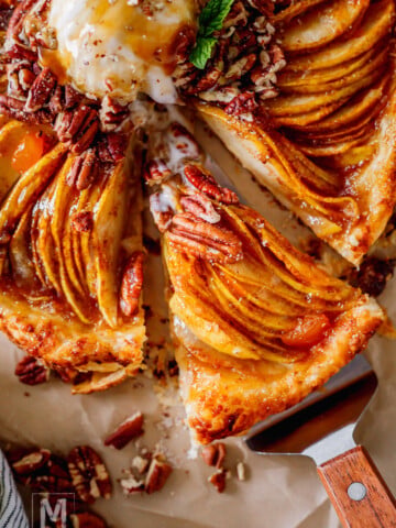 Pear galette with puff pastry served with vanilla bean ice cream, caramel drizzle, and crunchy pecans.